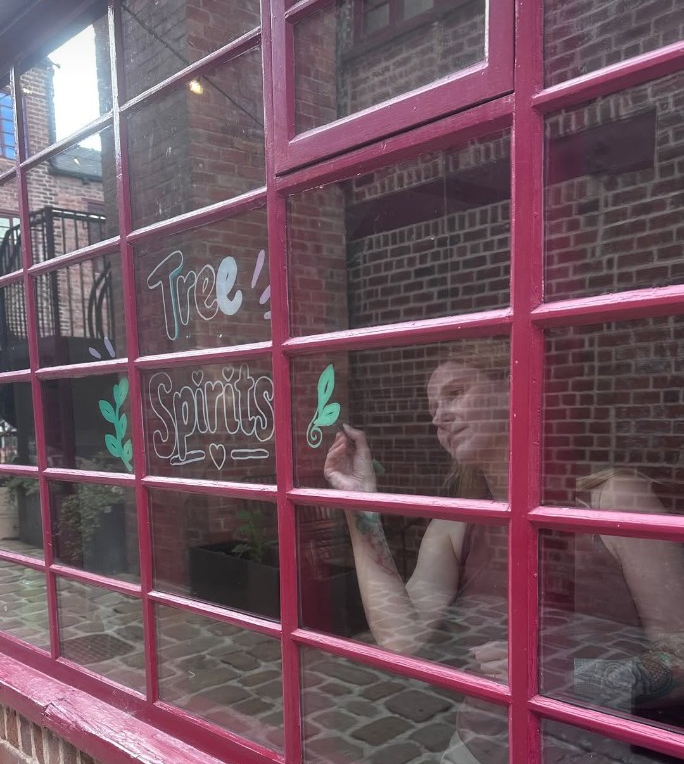 Painting the Tree Spirits lettering on the shop window.